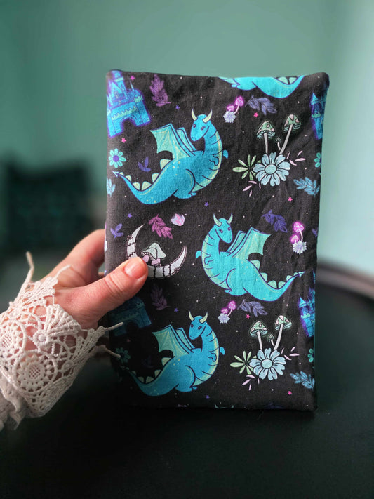 Couvre-livre en tissu fait main ,format broché, poche et relié tenu en main pour montrer la taille réelle