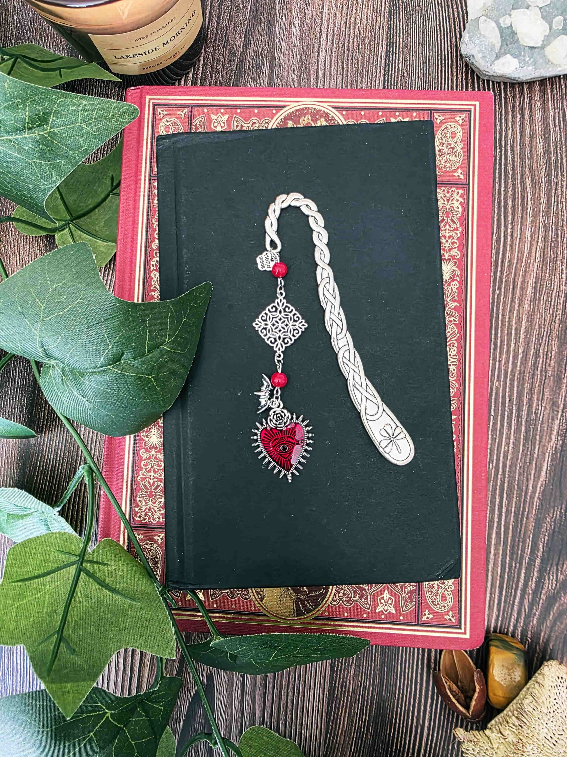Marque-page en métal vampire, chauve-souris avec un gros coeur rouge. Parfait pour les lecteur.ices de livres fantastiques, fantasy et gothique. Pierres naturelles personnalisables. Corail rouge. Bellette Workshop. belle photo