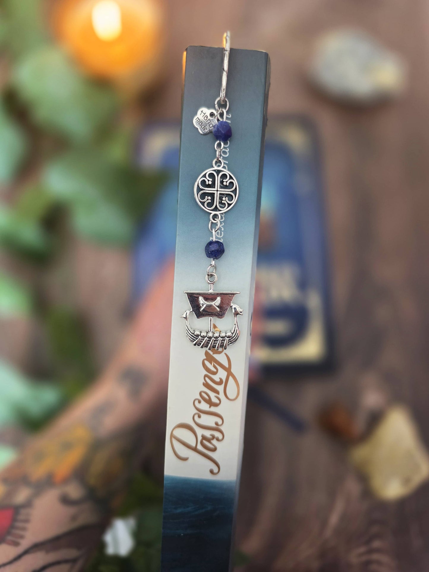 Marque-page en métal dragon oriental avec des pierres naturelles oeil-de-tigre. Les pierres sont personnalisables. Bellette Workshop. Metal bookmark with gemstones. Dans les pages d'un livre sur la mer