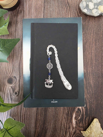 Marque-page en métal dragon oriental avec des pierres naturelles oeil-de-tigre. Les pierres sont personnalisables. Bellette Workshop. Metal bookmark with gemstones. sur un livre noir