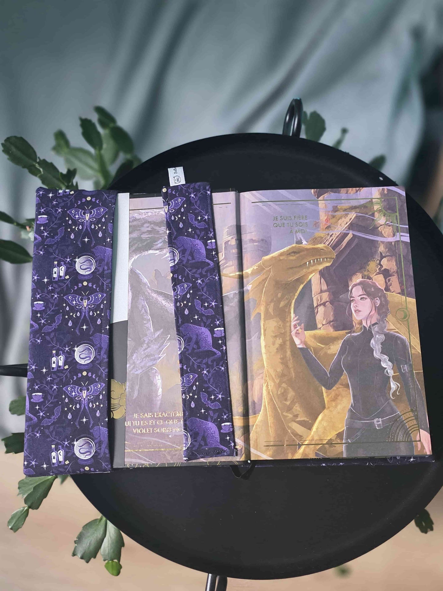 Couvre-livre artisanal ajustable aux nombres de pages et à l'épaisseur du livre. Motif tissu en coton chat  ésotérique, lune d'améthyste avec son marque-page en tissu assorti. Ouvert sur la premiere page du livre