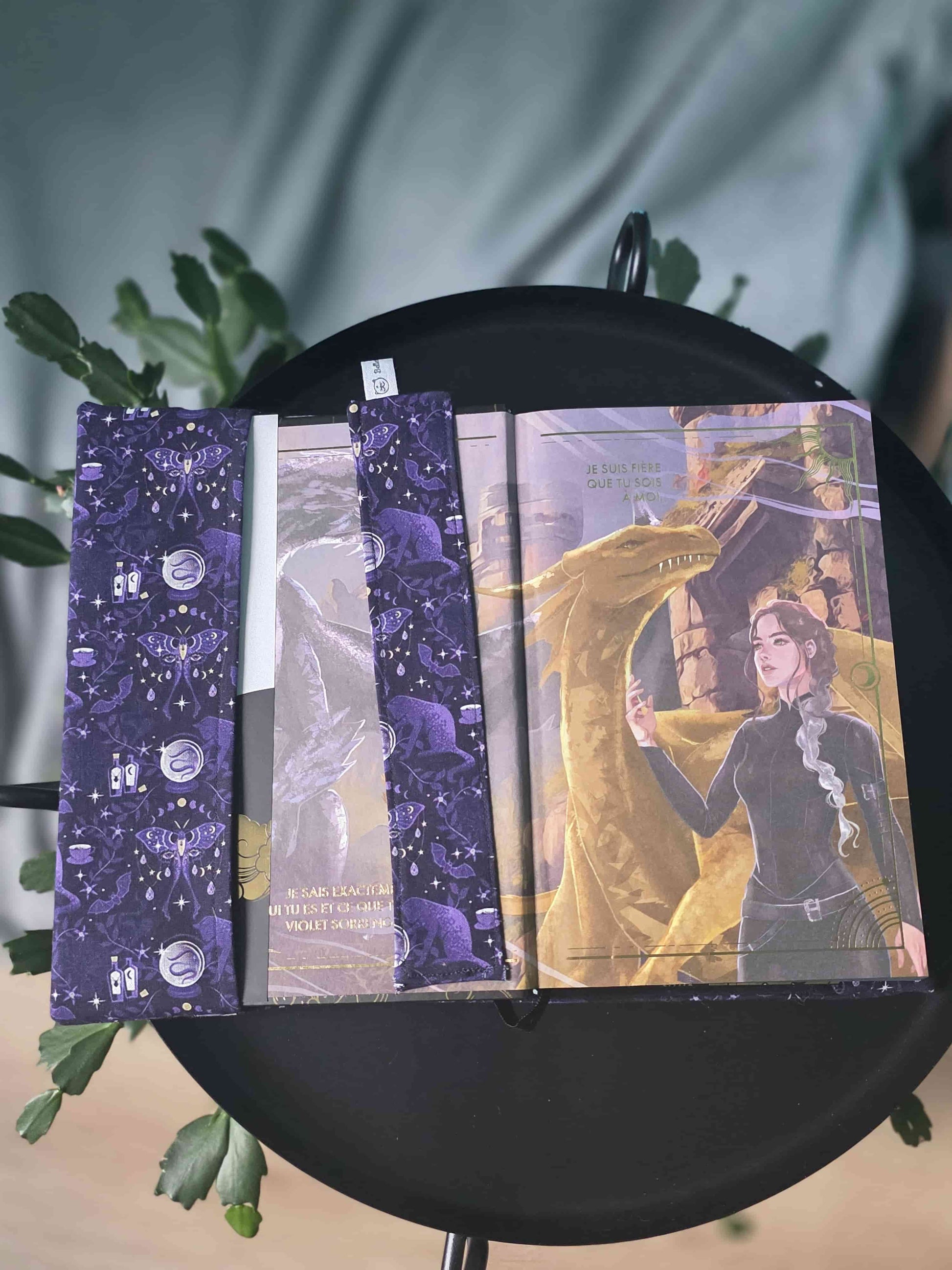 Couvre-livre artisanal ajustable aux nombres de pages et à l'épaisseur du livre. Motif tissu en coton chat  ésotérique, lune d'améthyste avec son marque-page en tissu assorti. Ouvert sur la premiere page du livre