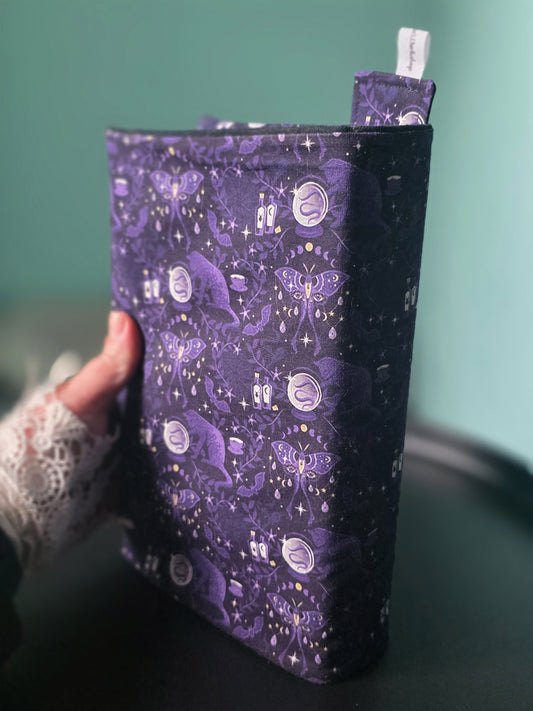 Couvre-livre artisanal ajustable aux nombres de pages et à l'épaisseur du livre. Motif tissu en coton chat  ésotérique, lune d'améthyste avec son marque-page en tissu assorti. tenu à la main