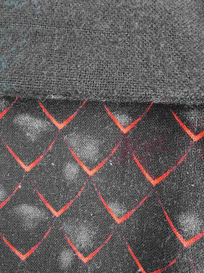 Détail du tisus écaille noir et rouge d'inspiration dragon, couture artisanale visible et flanelle de coton noire visible.