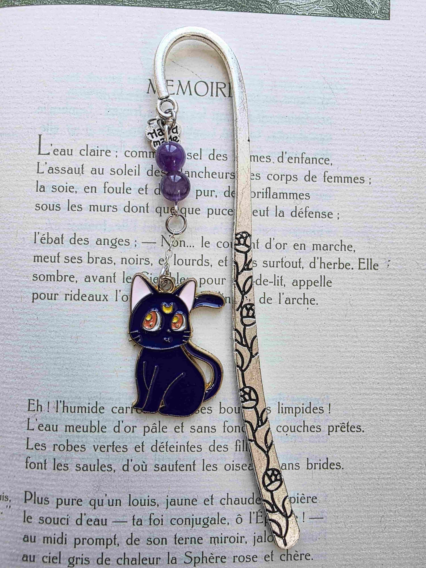 marque page en metal inspiré par les manga. Chat noir et chat blanc. Artemis et Luna. Pierres naturelles personnalisables. Améthyste sur le modèle. Fait main en France. Bookmark. Metal bookmark. chat noir uniquement posé dans un livre