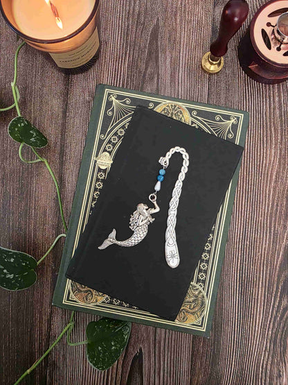 marque page en metal sirene, gardienne des abysses. Avec des pierres bleues d'apatite bleue et une goutte blanche. Pierres naturelles personnalisables. Signet artisanal Bellette Workshop. jolie photo 