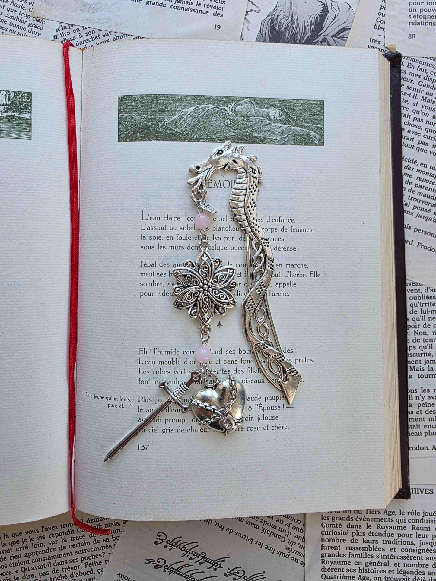 marque page metal avec une tige dragon, une fleur ciselée, une épée et un coeur brisé. Pierres naturelles de quartz rose personnalisable. Bellette Workshop. Fait main. Metal bookmark fantasy. Dark fantasy. Amour brisé. Cadeau fait main original pour lecteur et lectrice 