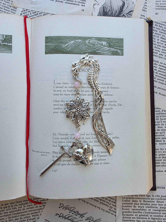 marque page metal avec une tige dragon, une fleur ciselée, une épée et un coeur brisé. Pierres naturelles de quartz rose personnalisable. Bellette Workshop. Fait main. Metal bookmark fantasy. Dark fantasy. Amour brisé. Cadeau fait main original pour lecteur et lectrice 