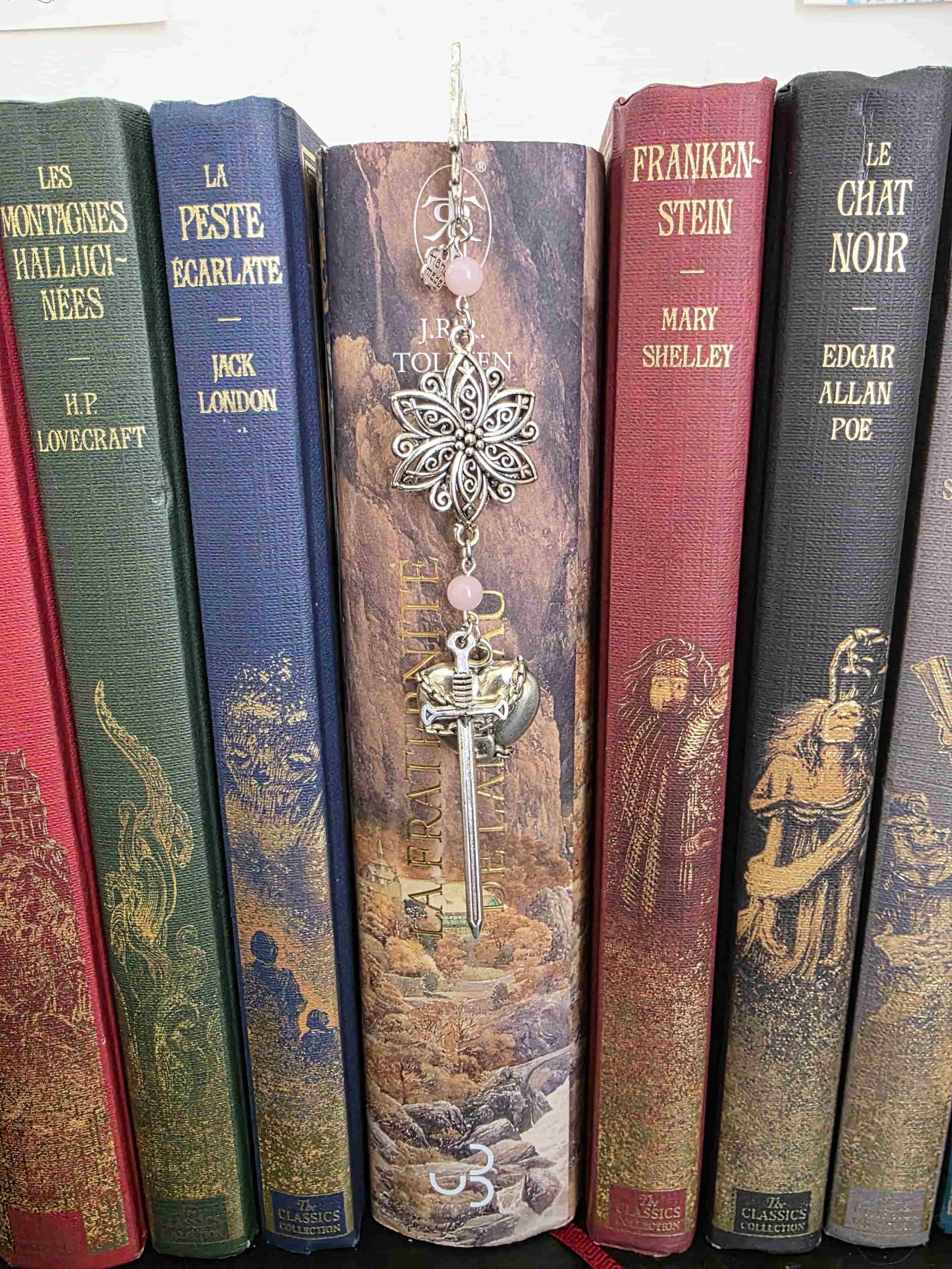 marque page metal avec une tige dragon, une fleur ciselée, une épée et un coeur brisé. Pierres naturelles de quartz rose personnalisable. Bellette Workshop. Fait main. Metal bookmark fantasy. Dark fantasy. Amour brisé. Cadeau fait main original pour lecteur et lectrice vu dans livre seigneur des anneaux