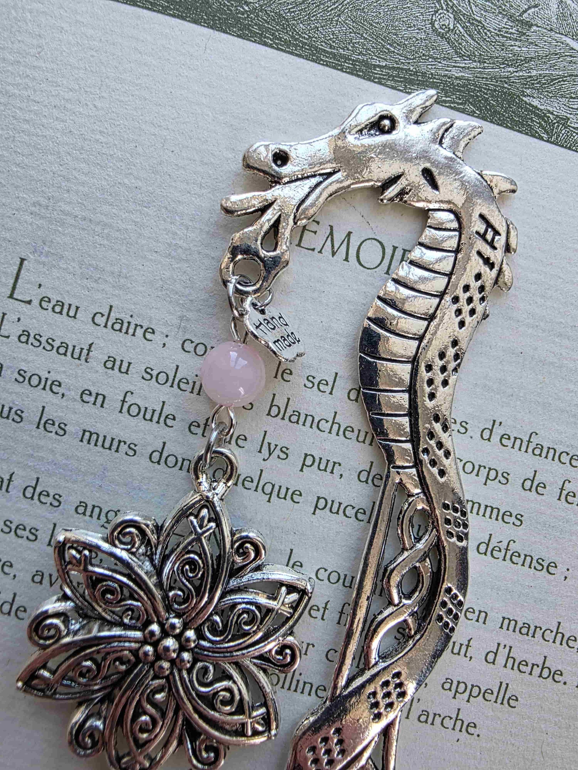 marque page metal avec une tige dragon, une fleur ciselée, une épée et un coeur brisé. Pierres naturelles de quartz rose personnalisable. Bellette Workshop. Fait main. Metal bookmark fantasy. Dark fantasy. Amour brisé. Cadeau fait main original pour lecteur et lectrice vu dragon de près