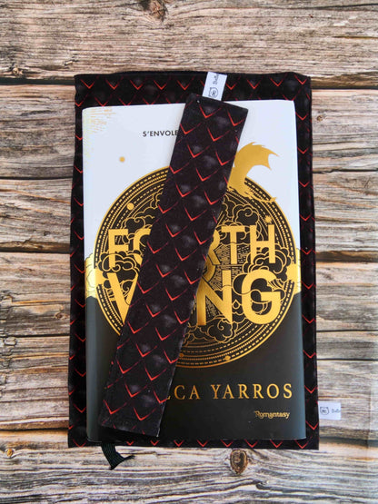 Pochette à livre écaille de dragon personnalisable posée sur le roman fourth wing, protection fantasy pour lecteur.