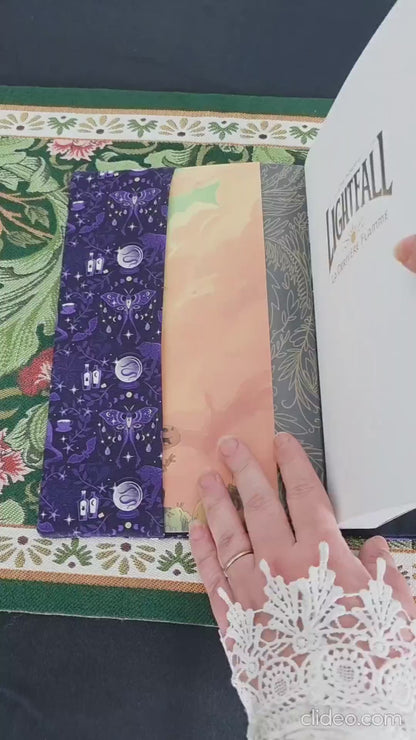 Vidéo de 10 secondes faisant la démonstration du couvre-livre artisanal ajustable aux nombres de pages et à l'épaisseur du livre. Motif tissu en coton chat  ésotérique, lune d'améthyste avec son marque-page en tissu assorti. 