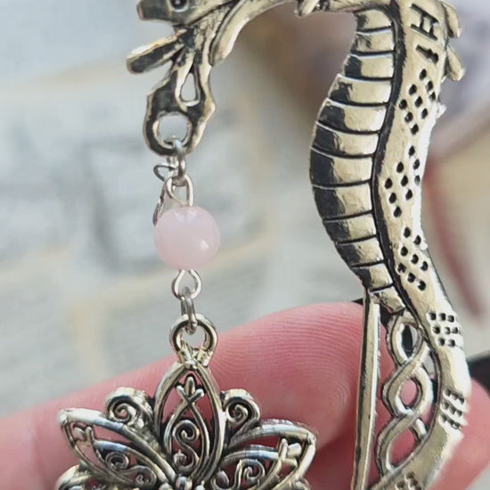vidéo du marque page metal avec une tige dragon, une fleur ciselée, une épée et un coeur brisé. Pierres naturelles de quartz rose personnalisable. Bellette Workshop. Fait main. Metal bookmark fantasy. Dark fantasy. Amour brisé. Cadeau fait main original pour lecteur et lectrice 