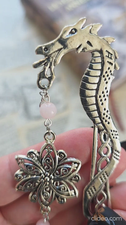 vidéo du marque page metal avec une tige dragon, une fleur ciselée, une épée et un coeur brisé. Pierres naturelles de quartz rose personnalisable. Bellette Workshop. Fait main. Metal bookmark fantasy. Dark fantasy. Amour brisé. Cadeau fait main original pour lecteur et lectrice 